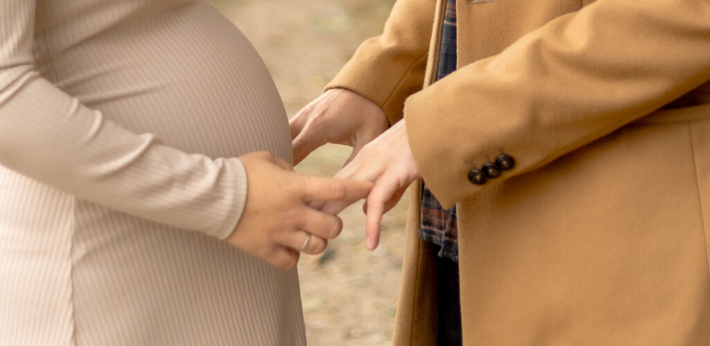 Nahaufnahme von Frau & Mann, die sich gegenüberstehende an den Hände halten