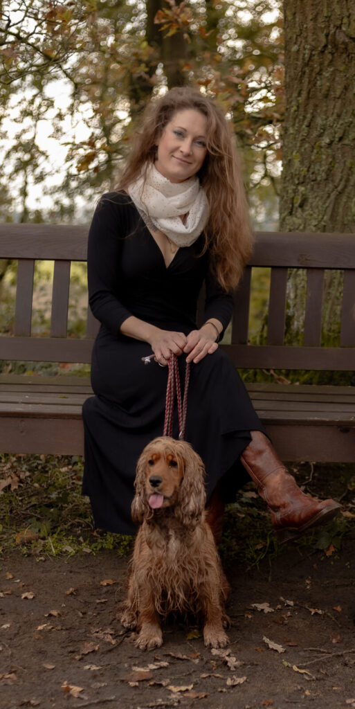 Mama sitzt mit Hund auf einer Parkbank