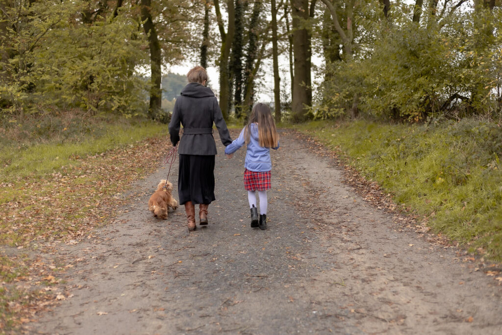 Mama & Tochter & Hund gehen von der Kamera weg