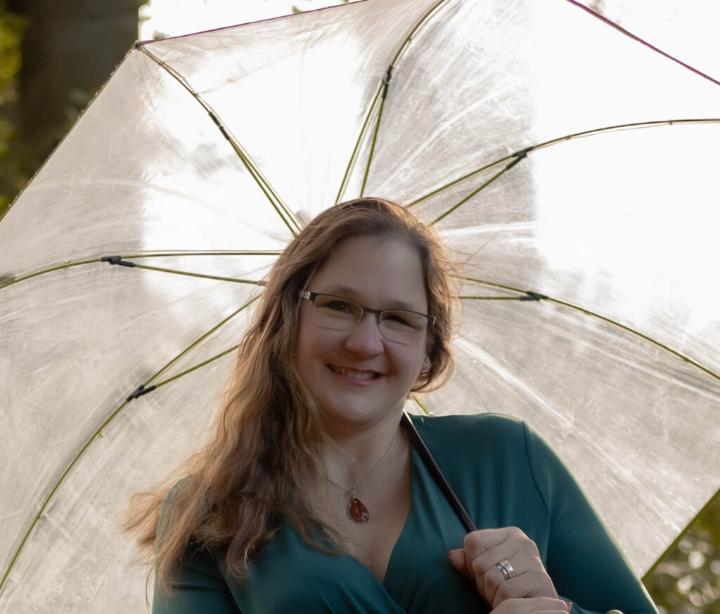 Frau hält Regenschirm über ihren Kopf