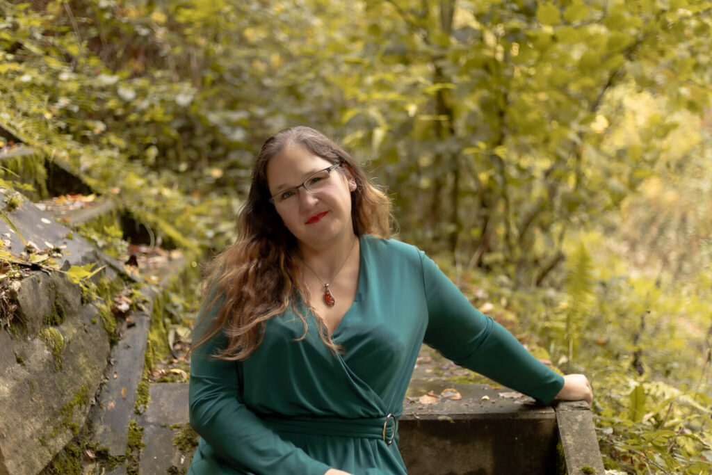 Frau sitzt auf einer Treppe & schaut zur Kamera